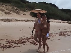 2 ladies with fabulous hooters are walking in the beach
